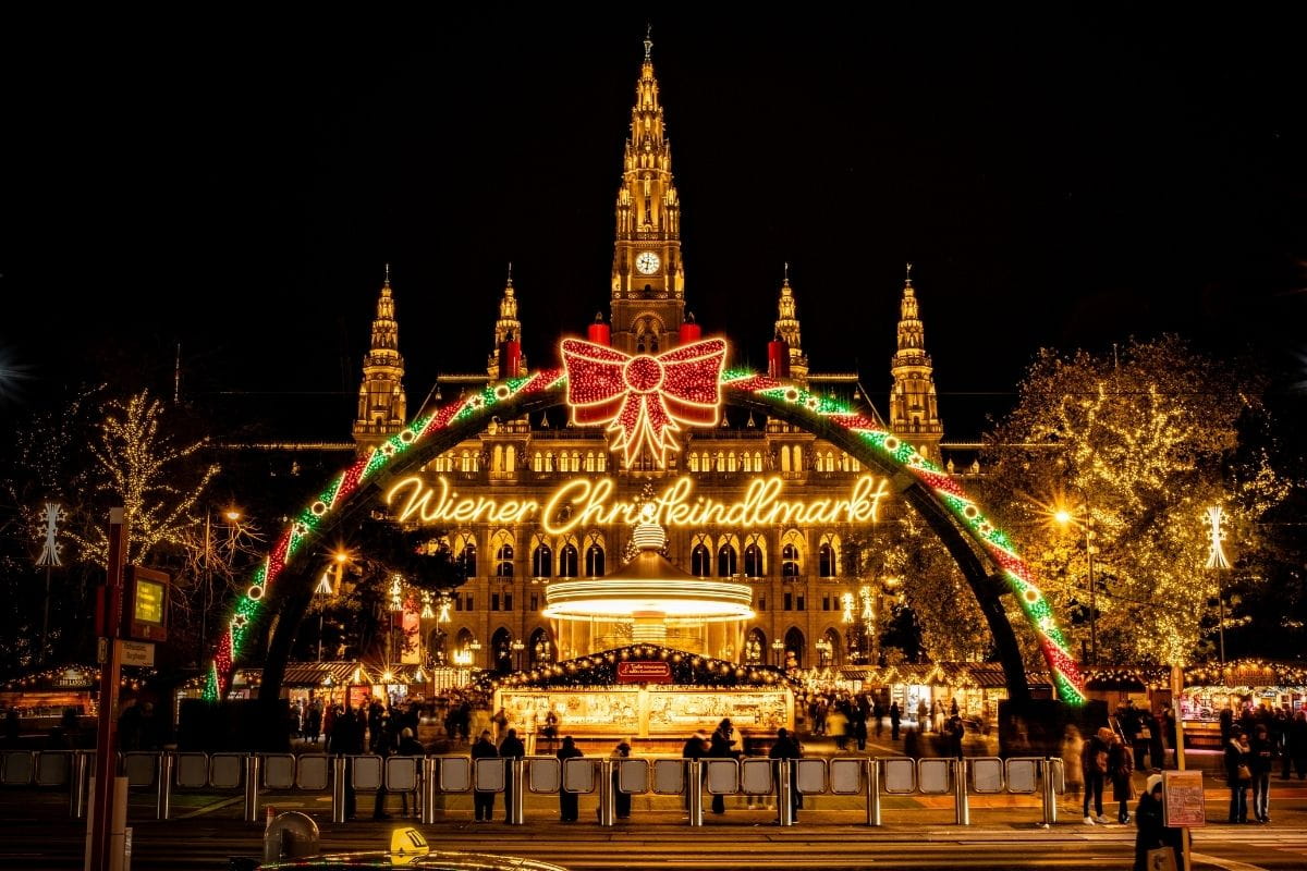 Christkindlmarkt am Rathausplatz beleuchtet am Abend von außen