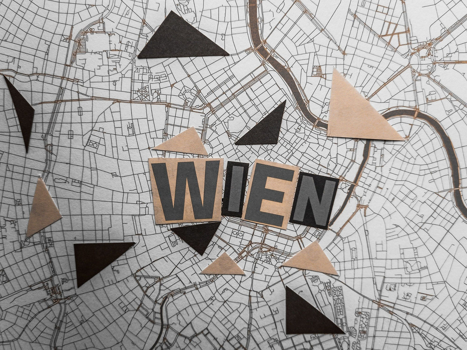 Stadtplan von Wien mit ausgeschnittenen Buchstaben und geometrischen Formen