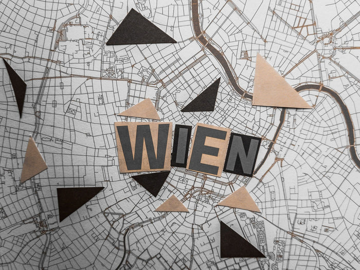 Stadtplan von Wien mit ausgeschnittenen Buchstaben und geometrischen Formen