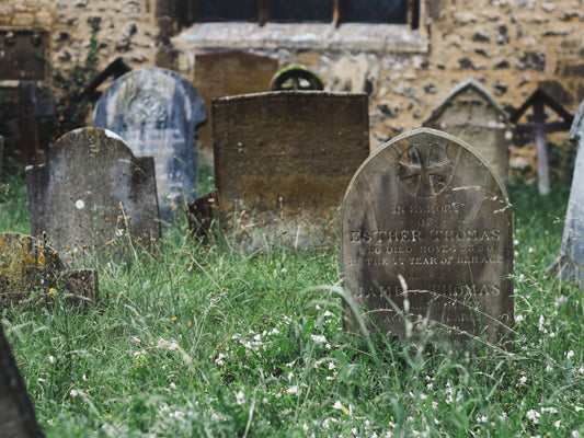 Alter Friedhof mit verwitterten Grabsteinen und überwucherten Gräbern