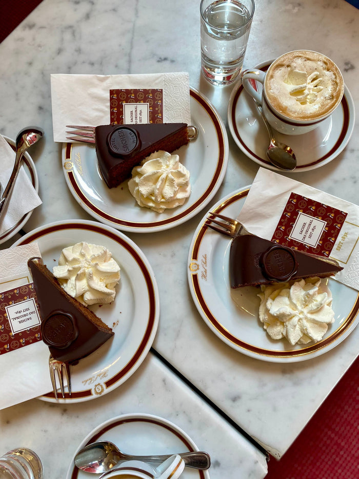 Angerichtete Sachertortenstücke vom Hotel Sacher mit Schlagobers auf einem Teller – Symbolbild für den Sachertorten-Streit zwischen Sacher und Demel